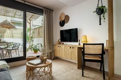 a dining room table with a book and two bottles at Bintan - 1 bedroom and terrace in Gràcia in Barcelona