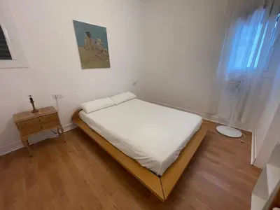 a small bedroom with a bed and a table at Barcelona Besos Apartment | 15' to Plaza Cataluña in Sant Adria de Besos