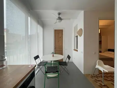 a kitchen with a table and chairs in a room at Barcelona Besos Apartment | 15' to Plaza Cataluña in Sant Adria de Besos