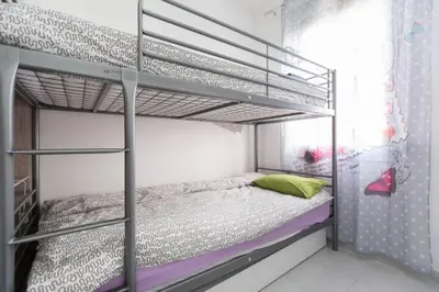 a bedroom with a bunk bed with purple and green pillows at Modern pad in a great old barrio in Barcelona