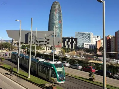 a train traveling down a street in a city at Modern pad in a great old barrio in Barcelona