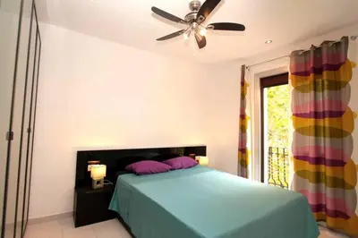 a bedroom with a bed with a ceiling fan at Modern pad in a great old barrio in Barcelona