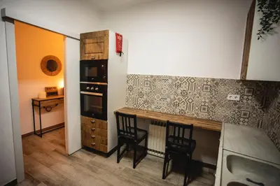 a kitchen with wooden cabinets and a stainless steel refrigerator at Habitación El Patufet en Casa Camí de les Aigües Monistrol de Montserrat in Monistrol