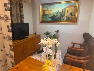 a living room with a tv and a painting on the wall at Habitación camp nou in Barcelona