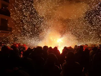 a crowd of people standing in front of a fireworks display at QEhome - confort, parking y cargador EV en el centro de Manresa in Manresa