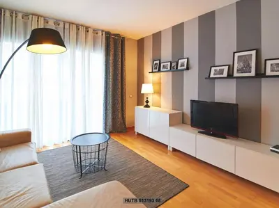 a living room with a couch and a television at Alcam Cervantes Playa Badalona in Badalona