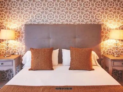 a bedroom with a large white bed with two lamps at Alcam Cervantes Playa Badalona in Badalona