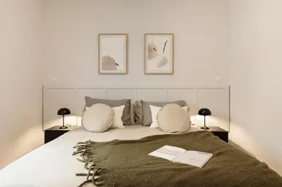 a bedroom with a bed with two lamps and a book at Enjoy Apartments Ecuador in Barcelona