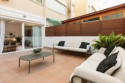 a patio with white couches and a coffee table at Enjoy Apartments Ecuador in Barcelona