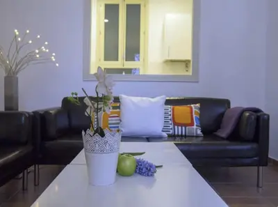 a living room with a couch and a table at Sitges Seafront BATLLÓ in Sitges