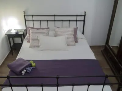 a bed with purple and white pillows on it at Sitges Seafront BATLLÓ in Sitges