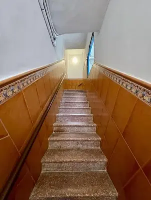 a staircase in a building with brown tiles at Sitges Seafront BATLLÓ in Sitges