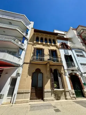 a building with a balcony on the side of it at Sitges Seafront BATLLÓ in Sitges
