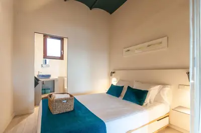 a bedroom with a large bed with blue pillows at ecoGrusApartments in Masnou
