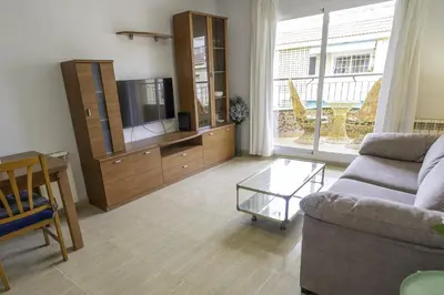 a living room with a couch and a tv at HomeHolidaysRentals Belisa - Costa Barcelona in Pineda de Mar