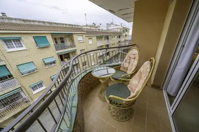a balcony with chairs and a table and a building at HomeHolidaysRentals Belisa - Costa Barcelona in Pineda de Mar