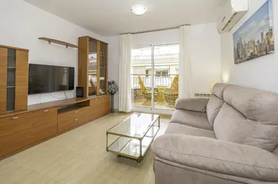 a living room with a couch and a tv at HomeHolidaysRentals Belisa - Costa Barcelona in Pineda de Mar
