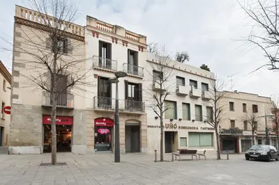a building on a street with a bench in front of it at Matarolux28 in Mataró