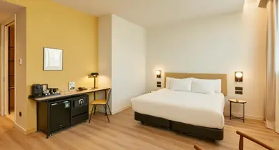 a hotel room with a bed and a desk at Sercotel Barcelona El Prat in El Prat de Llobregat