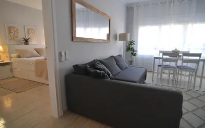 a living room with a couch and a bedroom at HomeHolidaysRentals Blue - Costa Barcelona in Pineda de Mar