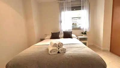 a bedroom with two towels on a bed with a window at Dúplex ático familiar by Prestigi in Terrassa
