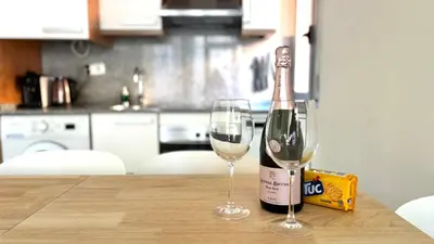 a bottle of wine and two glasses on a table at Dúplex ático familiar by Prestigi in Terrassa
