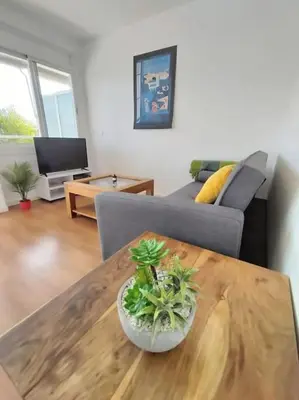 a living room with a table and a couch at Apartamento con vista al mar in Vilanova i la Geltrú