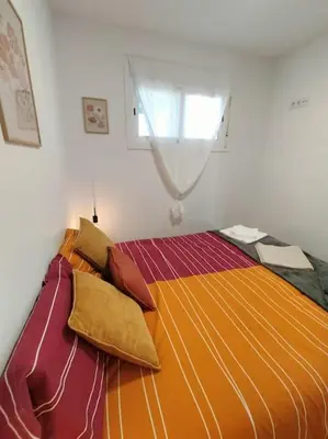 a bed with pillows on it in a bedroom at Apartamento con vista al mar in Vilanova i la Geltrú