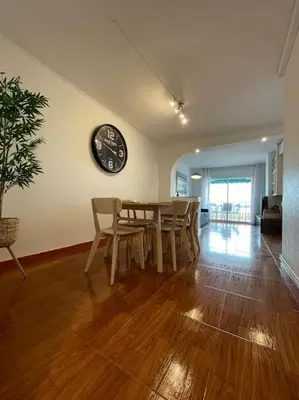 a dining room with a table and a clock on the wall at Apartamento en el centro urbano in Vilanova i la Geltrú