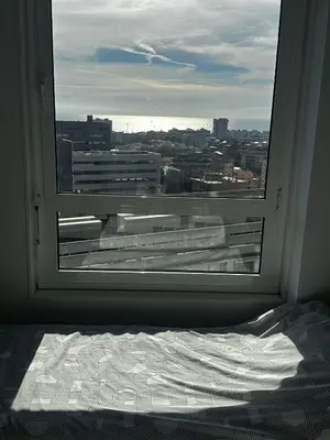a bedroom with a window looking out at a city at The Olive in Barcelona