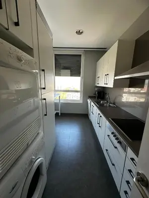 a small kitchen with white cabinets and a window at The Olive in Barcelona