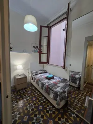 a bedroom with a bed and a window in it at Habitaciones Roger in Barcelona