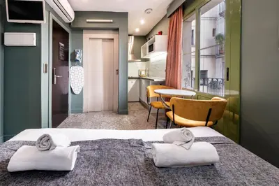 a hotel room with a bed and a table at AinB Born-Dames Apartments in Barcelona