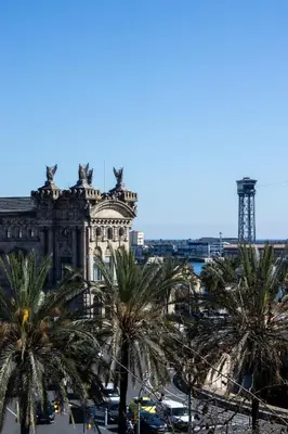 a building with palm trees in front of it at Apartments BCN Central-Colon in Barcelona