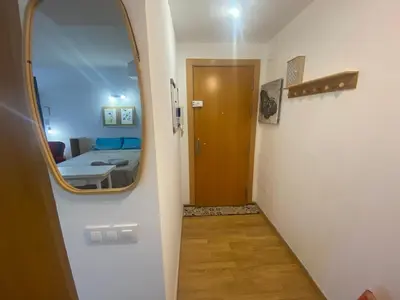 a hallway with a mirror and a room with a bed at Long Stays Terrassa Near Center in Terrassa