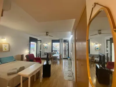 a bedroom with a bed and a mirror and a living room at Long Stays Terrassa Near Center in Terrassa