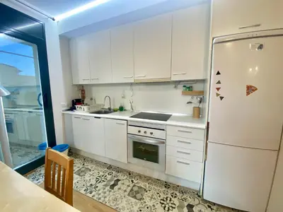 a kitchen with white cabinets and a refrigerator at Long Stays Terrassa Near Center in Terrassa