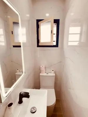 a white bathroom with a sink and a mirror at Casa Clot in Barcelona