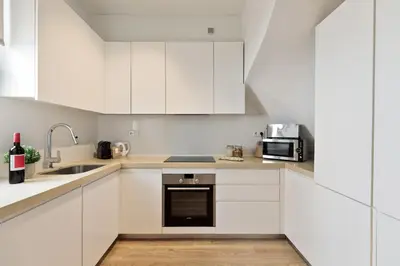 a white kitchen with a sink and a microwave at Ola Living Poblenou Beach in Barcelona