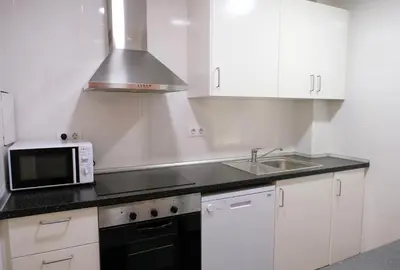 a white kitchen with a microwave and a sink at Apartments BCN Central-Drassanes in Barcelona