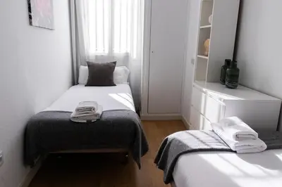 a small room with two beds and a window at Apartments BCN Central-Drassanes in Barcelona