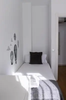 a white bedroom with a bed with white walls at Apartments BCN Central-Drassanes in Barcelona
