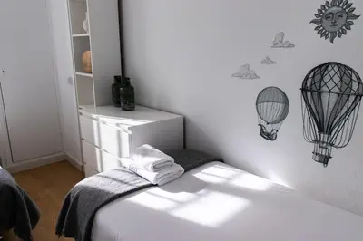 a white room with a bed with a cage on the wall at Apartments BCN Central-Drassanes in Barcelona