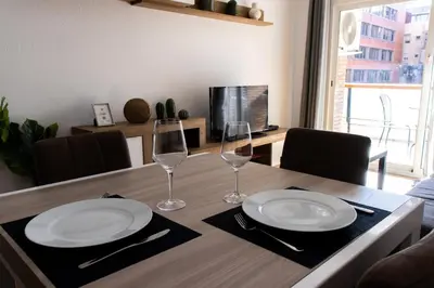 a dining room table with two glasses and plates on it at Apartments BCN Central-Drassanes in Barcelona