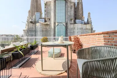 a table and chairs on a balcony with a cathedral at Sagrada in Barcelona