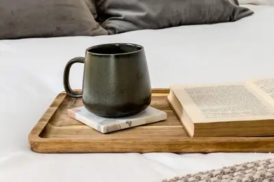 a coffee cup and a book on a tray on a bed at Sagrada in Barcelona