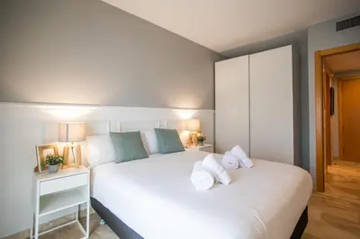 a bedroom with a white bed with towels on it at 13MAL1077- Magnific 2BR flat in Barcelona
