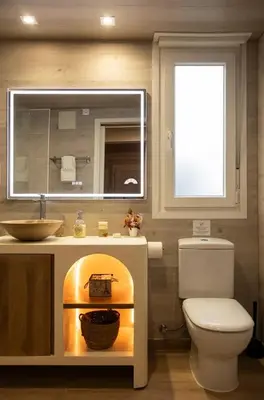 a bathroom with a toilet and a sink and a mirror at Hogar con encanto y personalidad in L'Ametlla del Vallès
