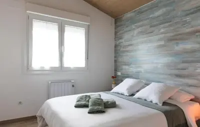 a bedroom with a large bed with towels on it at Hogar con encanto y personalidad in L'Ametlla del Vallès