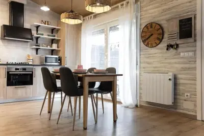 a dining room with a table and chairs and a clock at Hogar con encanto y personalidad in L'Ametlla del Vallès